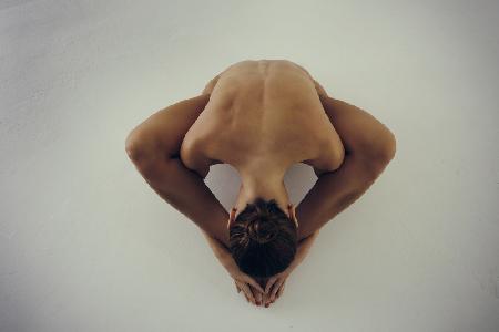 the triangle of sensuality. A  naked girl poses with sensual and provocative asanas in photostudio