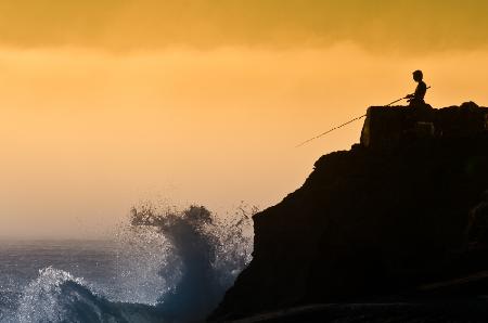 Seashore, sunset and the fisherman