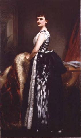 Portrait of a young woman wearing a striped dress and standing in an interior