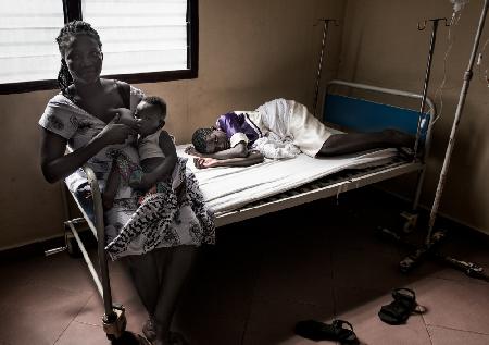 A grandmother breastfeeds her grandson while visiting her sick daughter - Ghana