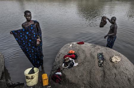 Mundari tribe women cleaning clothes in the river - South Sudan