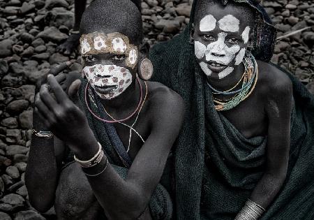 Two surmi girl painting in the bank of a river - Ethiopia