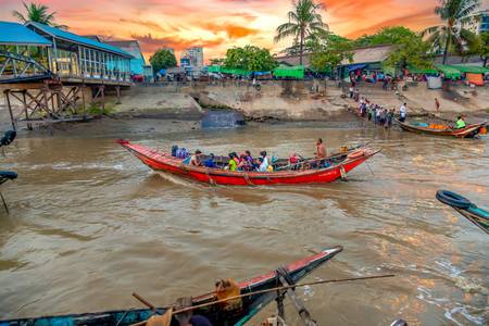 Sonnenuntergang am Fluss, Boote mit Menschen in Yangon, Myanmar.