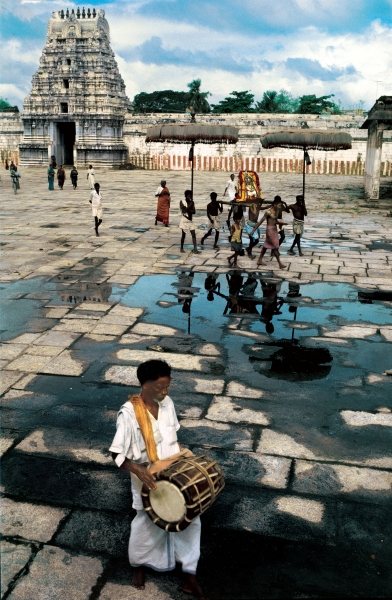 Drummer and devotees reflected in pool of water (photo)  from 
