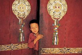 Young initiate outside main door of Pemyangtse monastery (photo) 