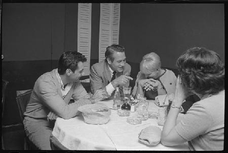 Paul Newman, Mort Sahl and Joanne Woodward joking at dinner