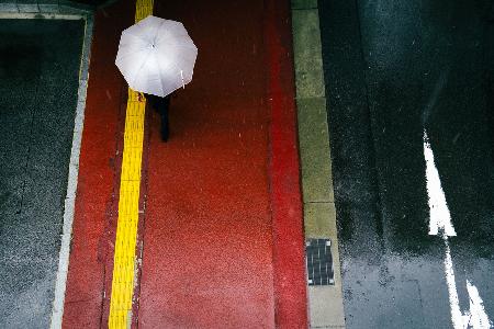 The red sidewalk and a white umbrella